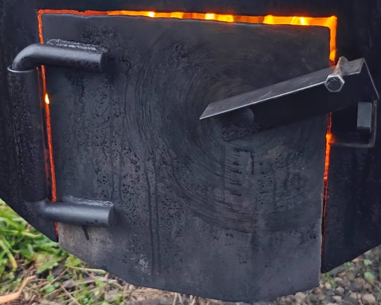 Firebox door of the Briar Ridge BBQ offset smoker glowing with oak coals